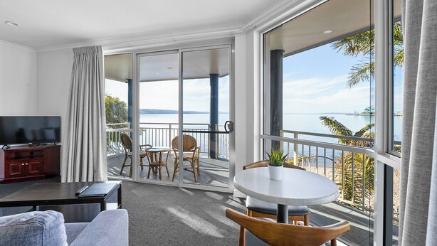 A hotel room with a balcony, a TV, a sofa, and a dining table. - Best Western Port Lincoln (Port Lincoln)