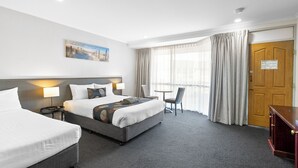 A hotel room with two beds, a desk, a chair, and a large window with curtains. - Best Western Port Lincoln (Port Lincoln)