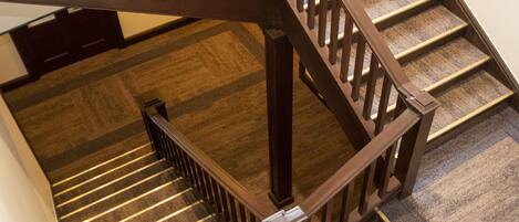 A wooden staircase with carpeted steps and a handrail.