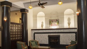 A lobby with a fireplace, two armchairs, and a sign reading "Hydro Hotel". - Hydro Hotel (Leeton)