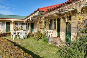 A building with a covered outdoor seating area, a green roof, and a number '1' on the door. - Wintersun Gardens Motel (Bicheno)