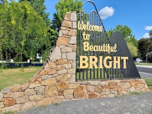 A stone wall with a metal gate and a sign that reads "Welcome to Beautiful BRIGHT".