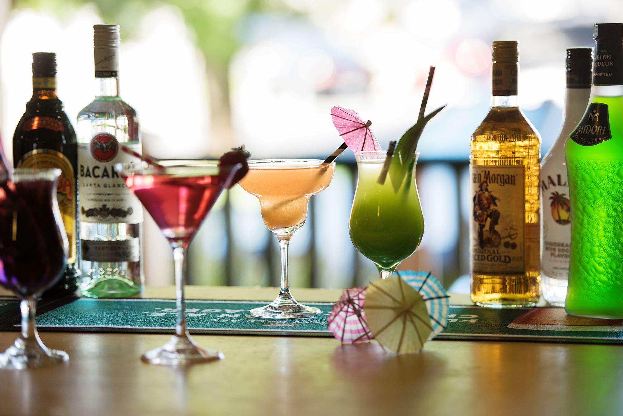 A bar setting with various bottles and glasses of drinks.