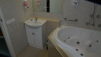 Un baño con lavabo, espejo y bañera.
