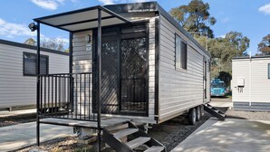 Un camper con veranda coperta e una piccola scala che conduce all'ingresso.