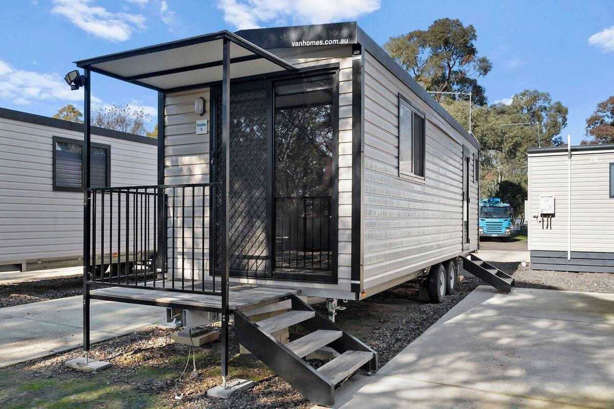 A mobile home with a covered porch and a small staircase leading to the entrance.