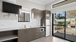 Una cucina moderna con forno a microonde integrato, lavello e finestra con vista su un patio.