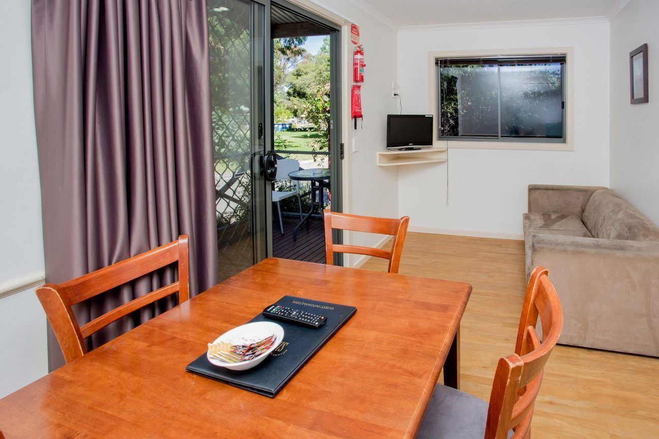 A dining area with a wooden table, chairs, and a plate of food.