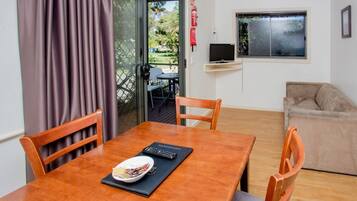A dining area with a wooden table, chairs, and a plate of food.