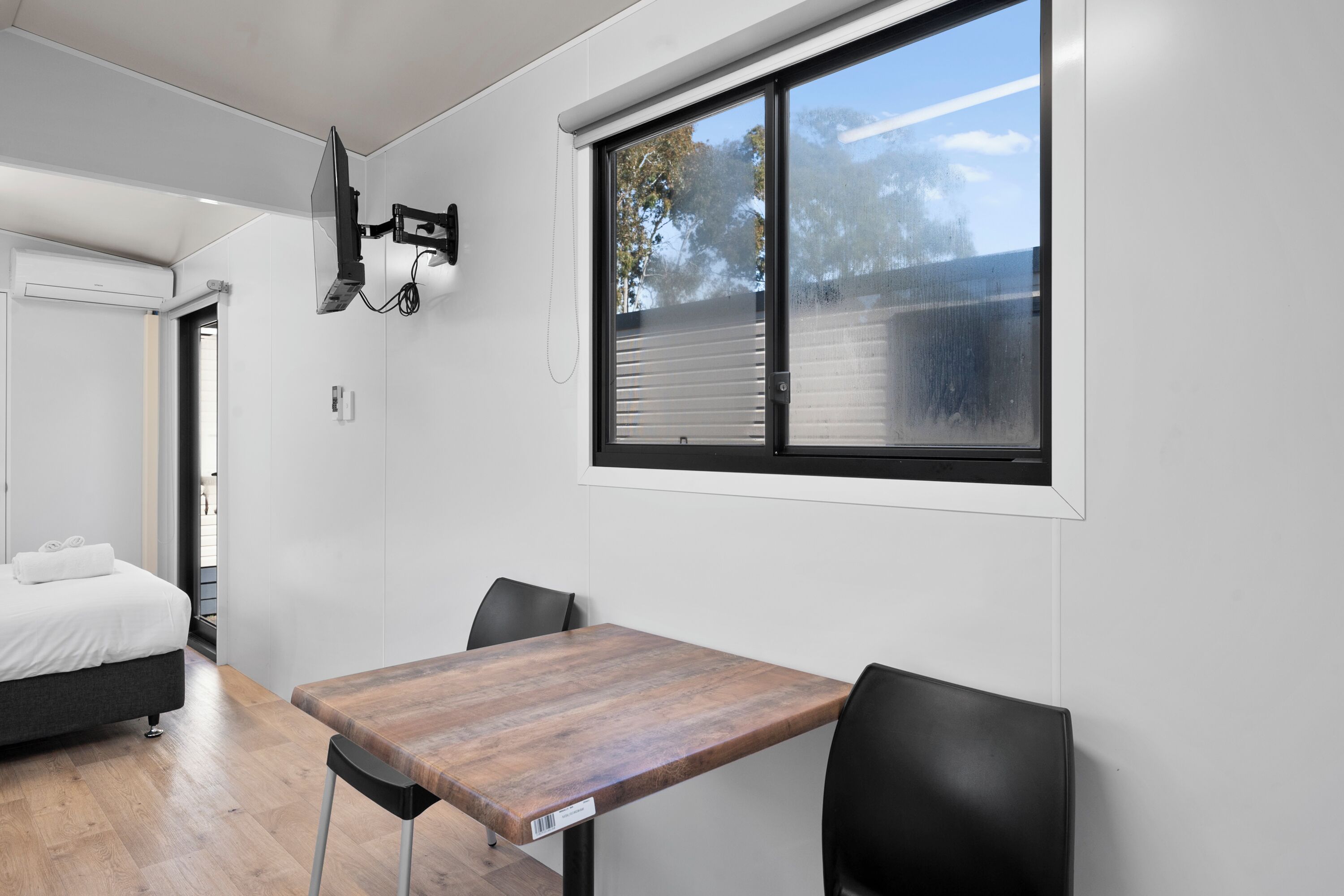 A modern room with a bed, a table, and a window.