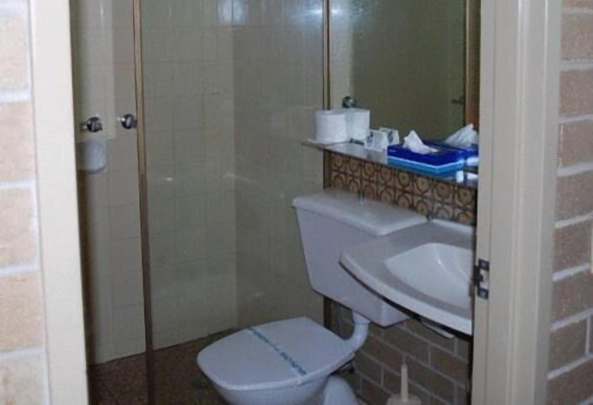 Un baño con inodoro, lavamanos y ducha.