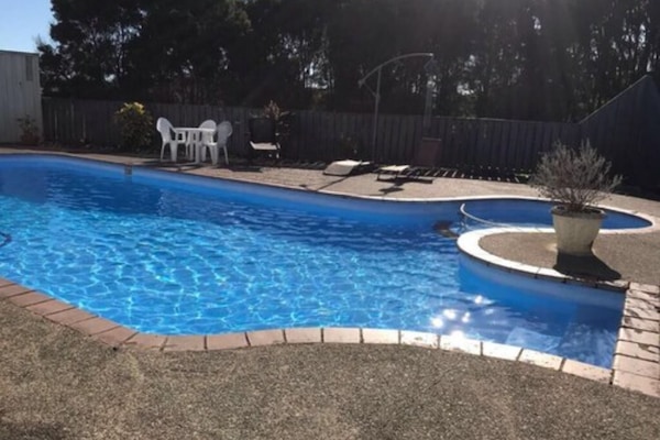 Una piscina al aire libre, tumbonas