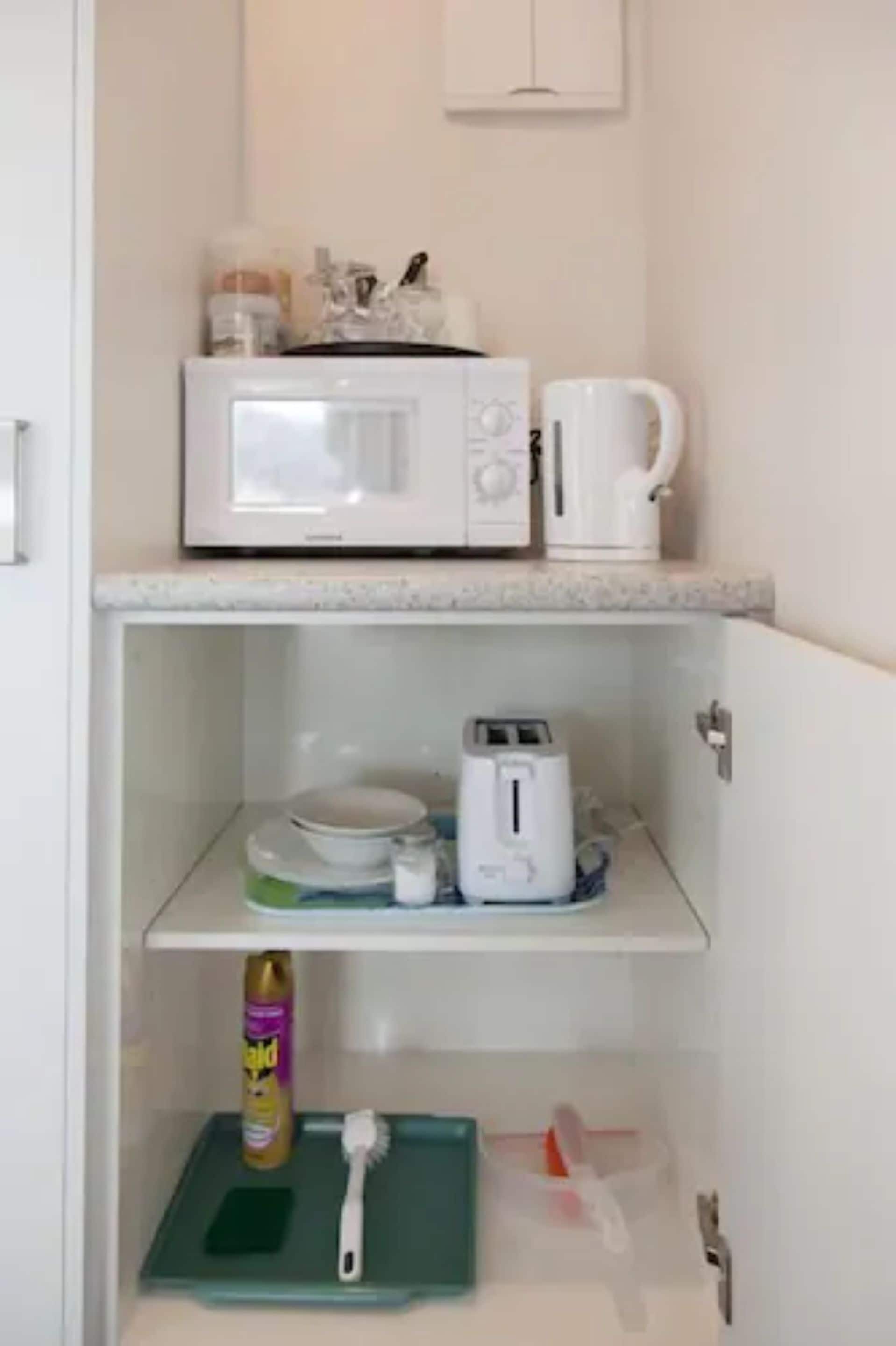 A kitchen with a microwave, toaster, and coffee maker on the countertop.