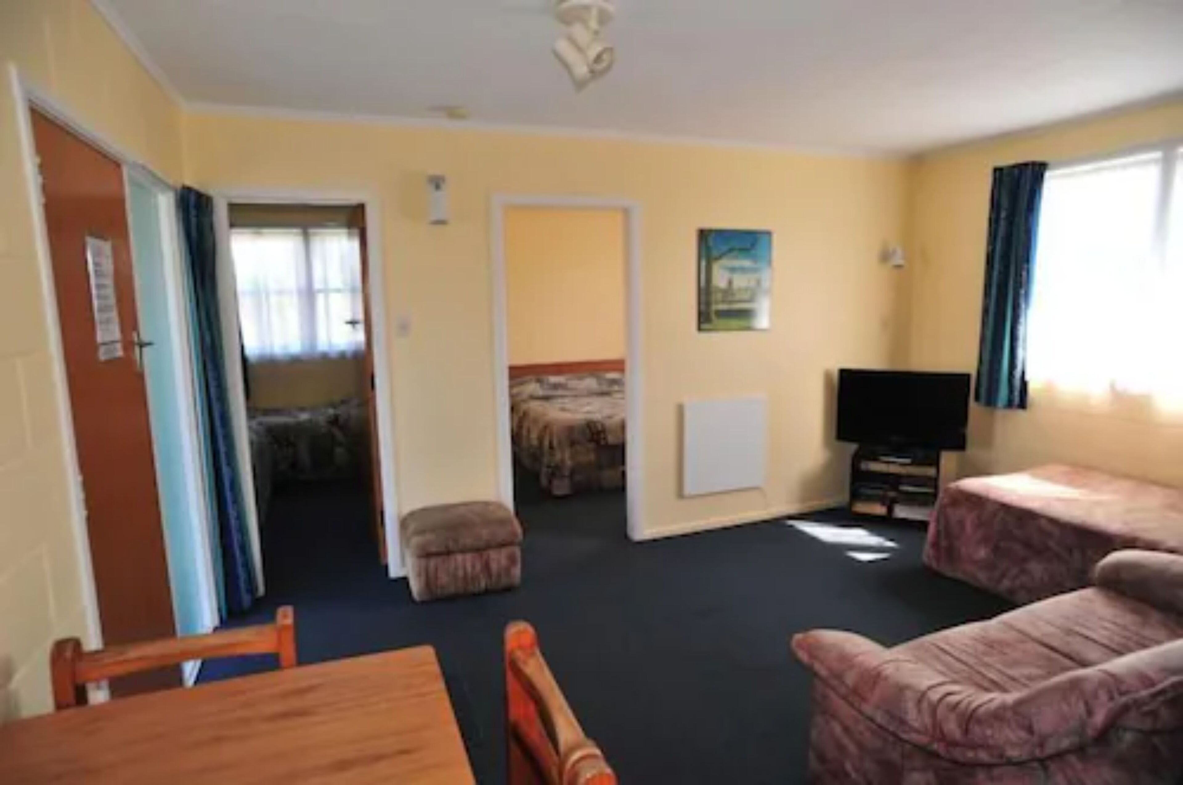 Ein Zimmer mit einem Bett, einem Fernseher, einem Esstisch und einer Couch.