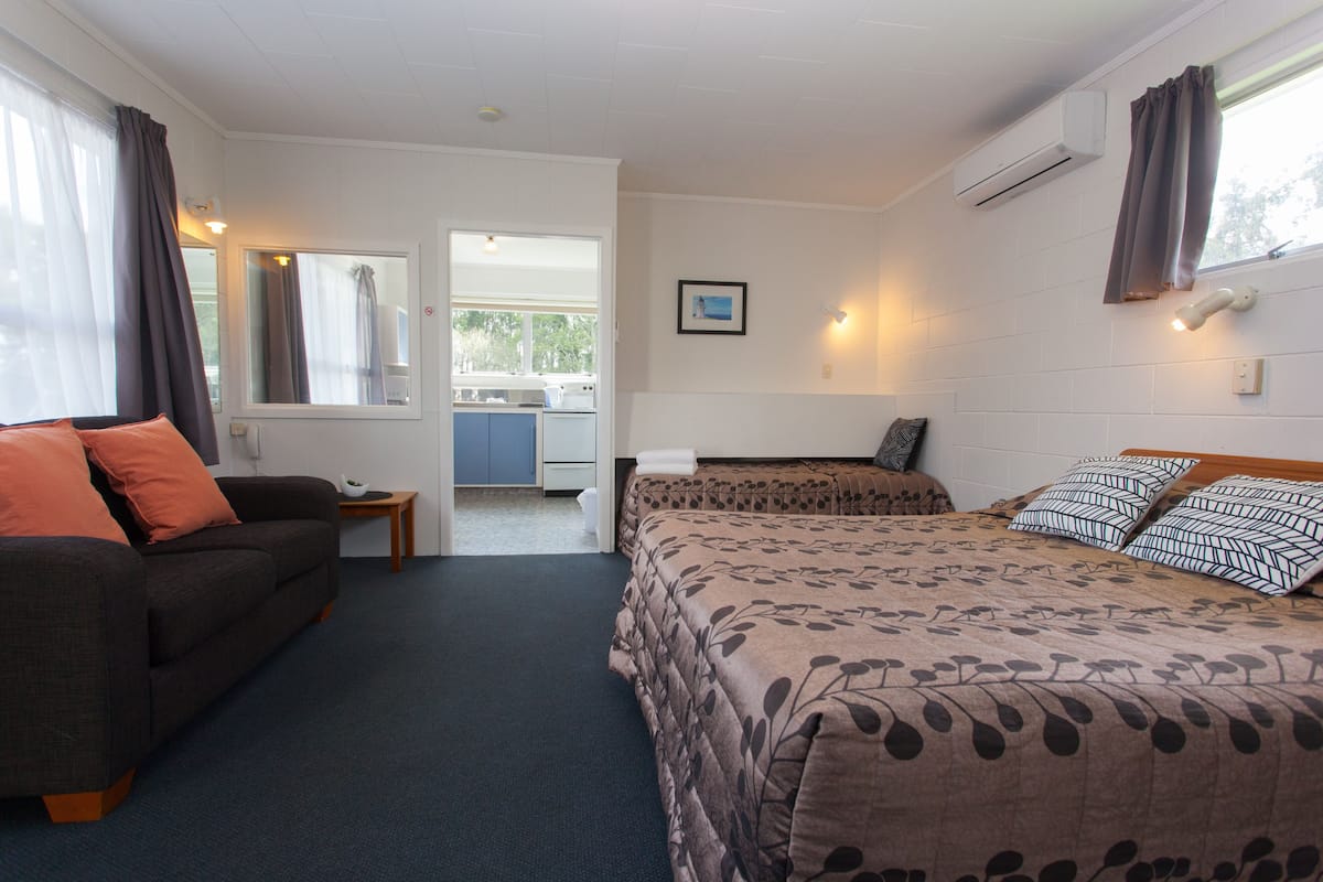 A bedroom with a bed, a sofa, and a small table.