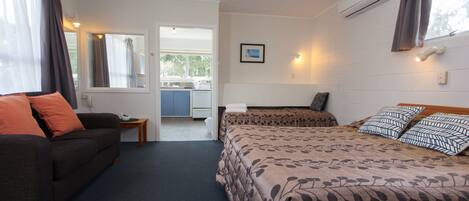 A bedroom with a bed, a sofa, and a small table.