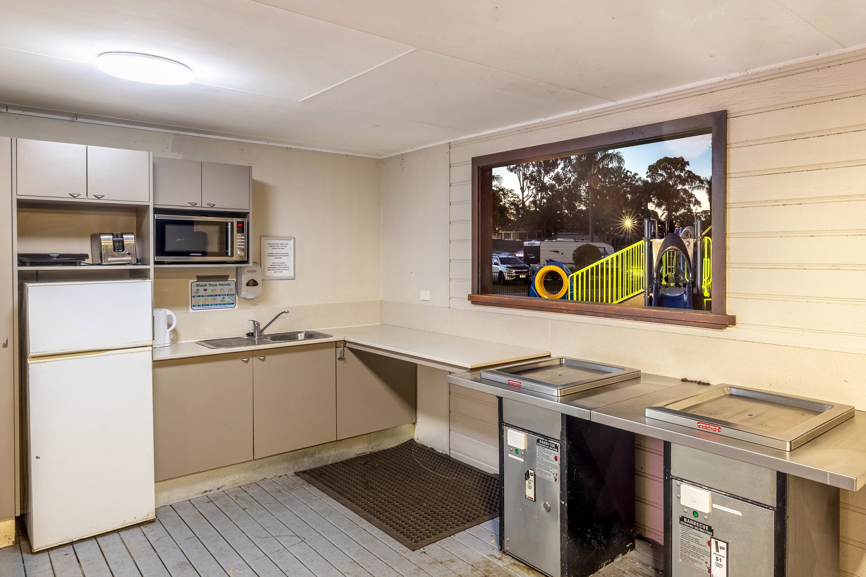 A kitchenette with a microwave, toaster, sink, and a small refrigerator.