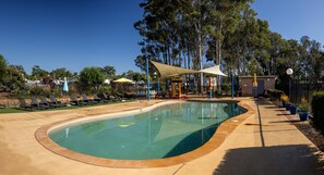 A swimming pool with lounge chairs and a shaded area. - BIG4 Karuah Jetty Holiday Park (Karuah)