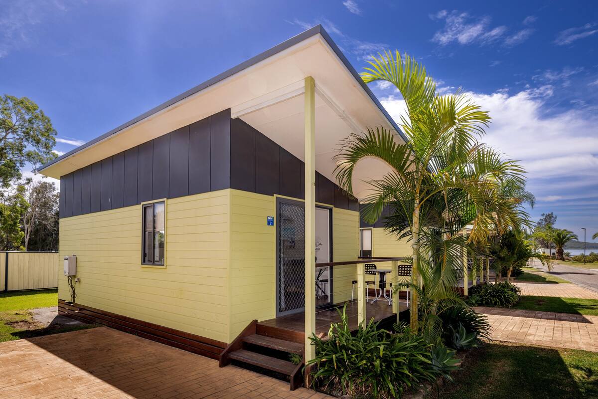 A modern two-story building with a flat roof and a covered porch.