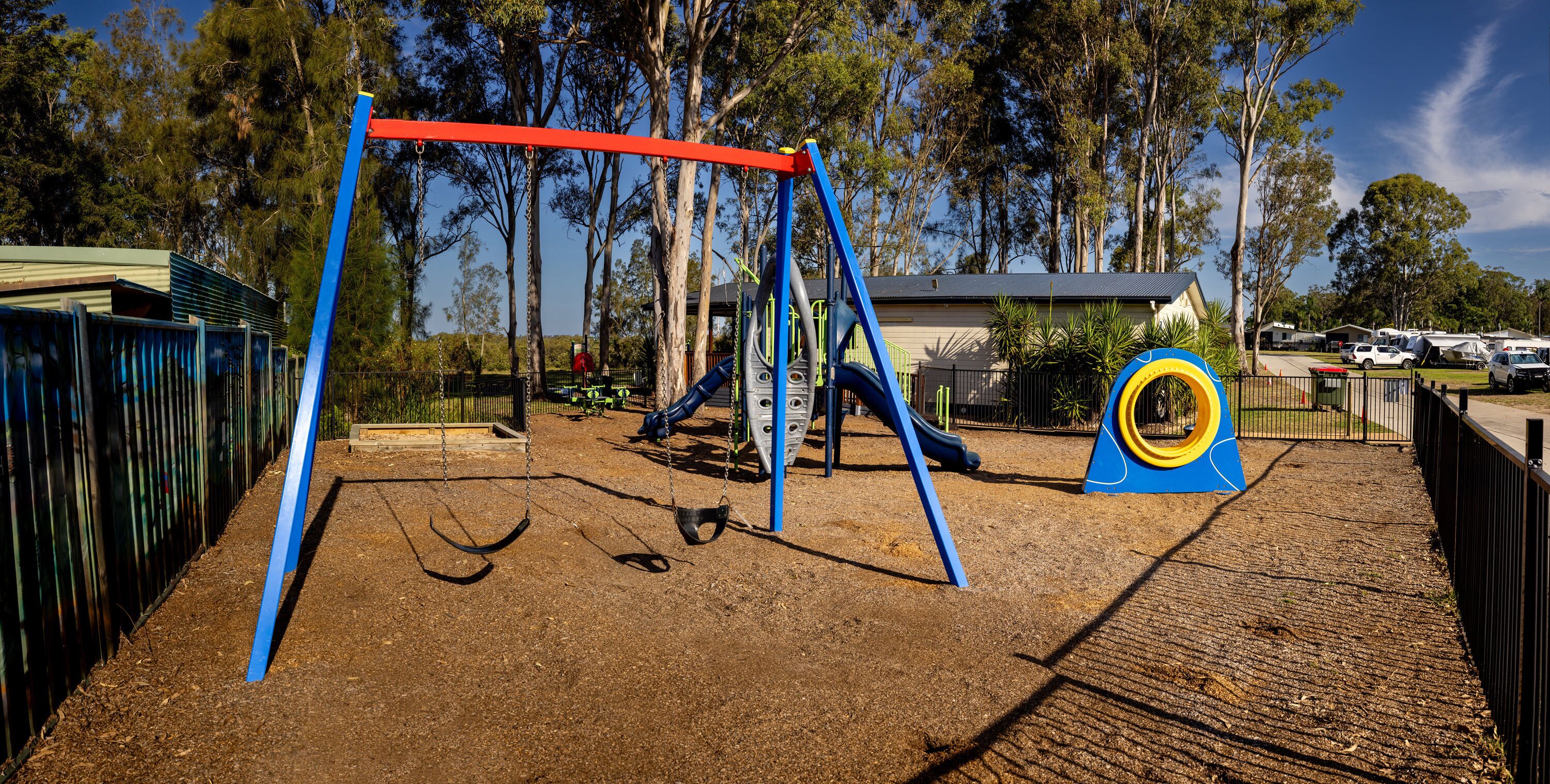 A playground with swings, a slide, and a climbing structure.