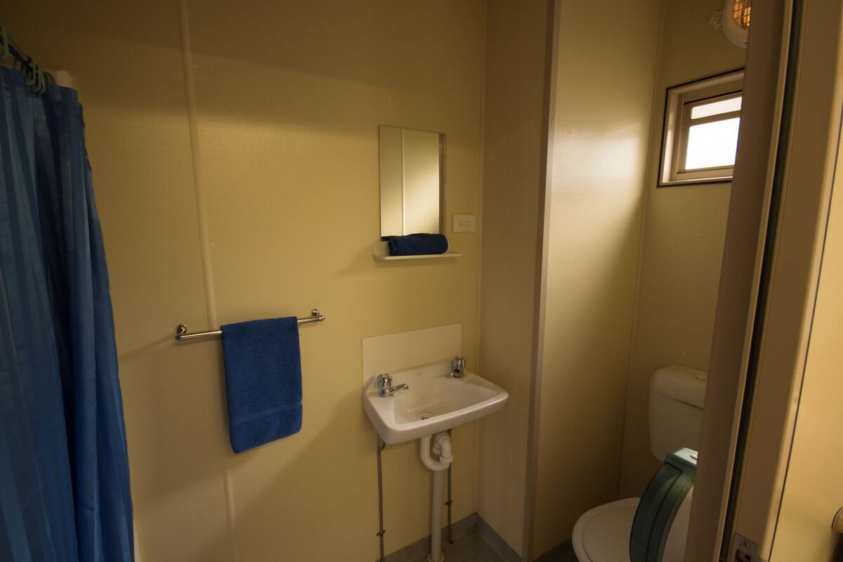 Ein kleines Badezimmer mit Waschbecken, Spiegel und Toilette.