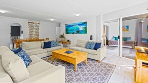 Una sala moderna con un conjunto de sofá, una mesa de centro y un cuadro de una escena de playa.
