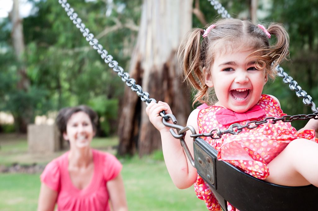 A child on a swing in a park.