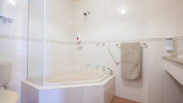 A bathroom with a bathtub, toilet, and shower.