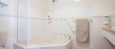 Un baño con bañera, inodoro y ducha.