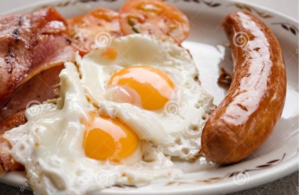 A plate with two sunny-side-up eggs, a sausage, and bacon strips. - Mid City Motel - Mount Gambier (Mount Gambier)