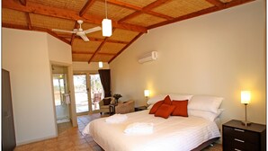A bedroom with a bed, bedside lamps, a ceiling fan, and a window. - Mungo Lodge (Arumpo)