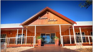 A wooden lodge with a red roof and the name 'Mungo Lodge' on the facade. - Mungo Lodge (Arumpo)