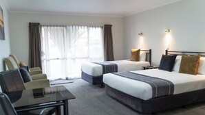 Habitación de hotel con dos camas, un escritorio y una silla.