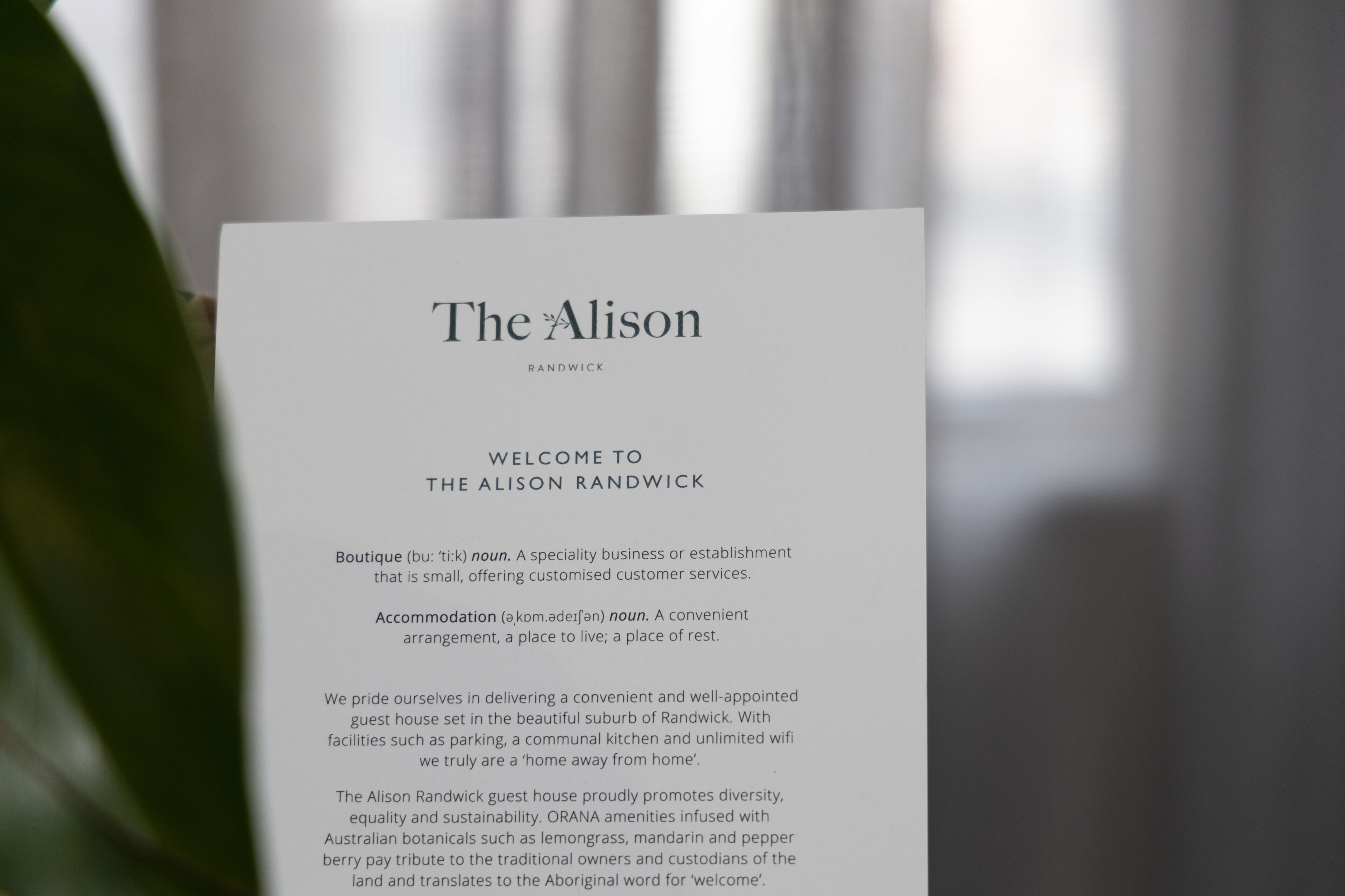 Letrero de bienvenida del Alison Randwick, un hotel boutique que ofrece un hogar lejos del hogar con servicios como estacionamiento, cocina compartida y wifi ilimitado.