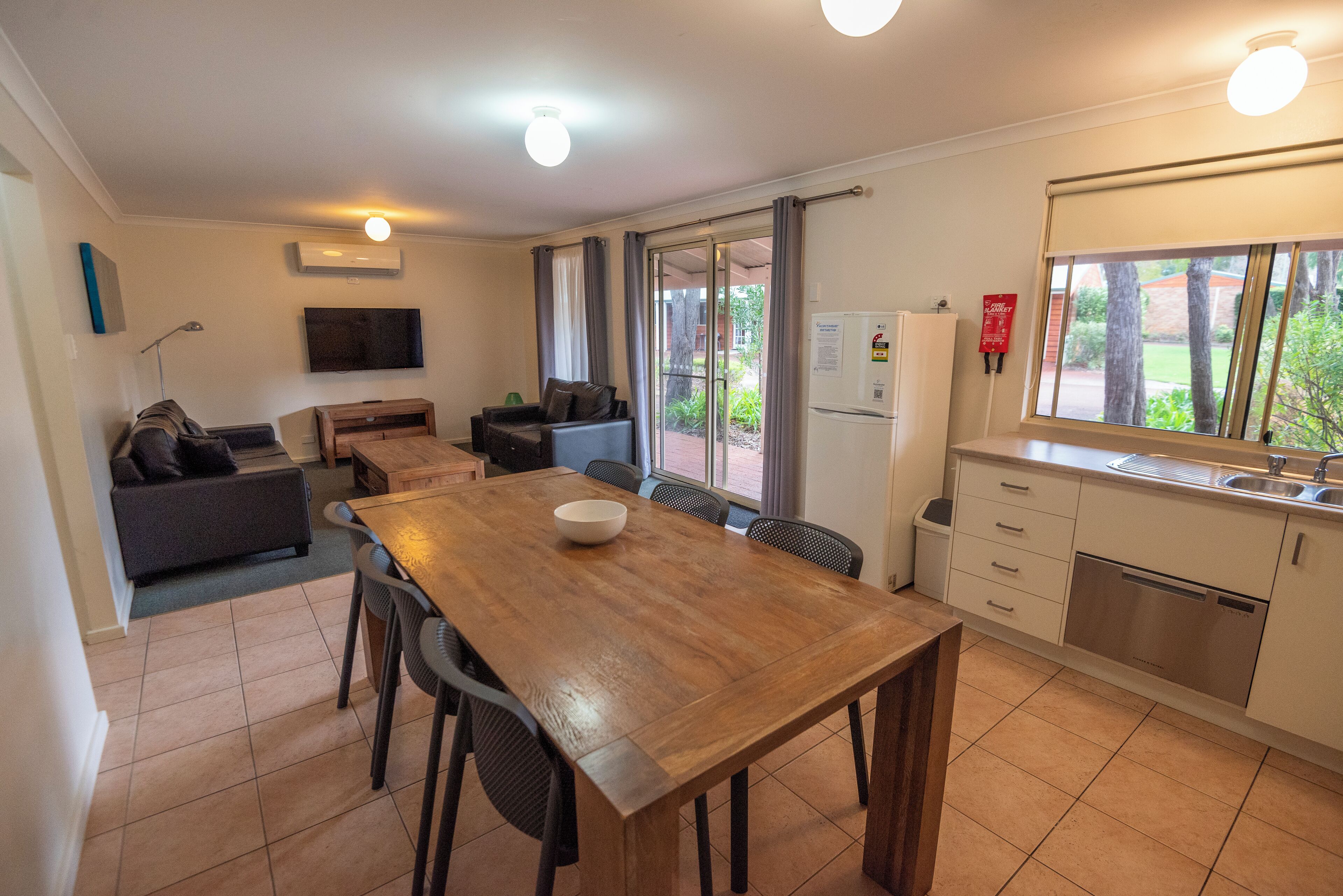 Un espacio habitable compacto con comedor, kitchenette y sofá.