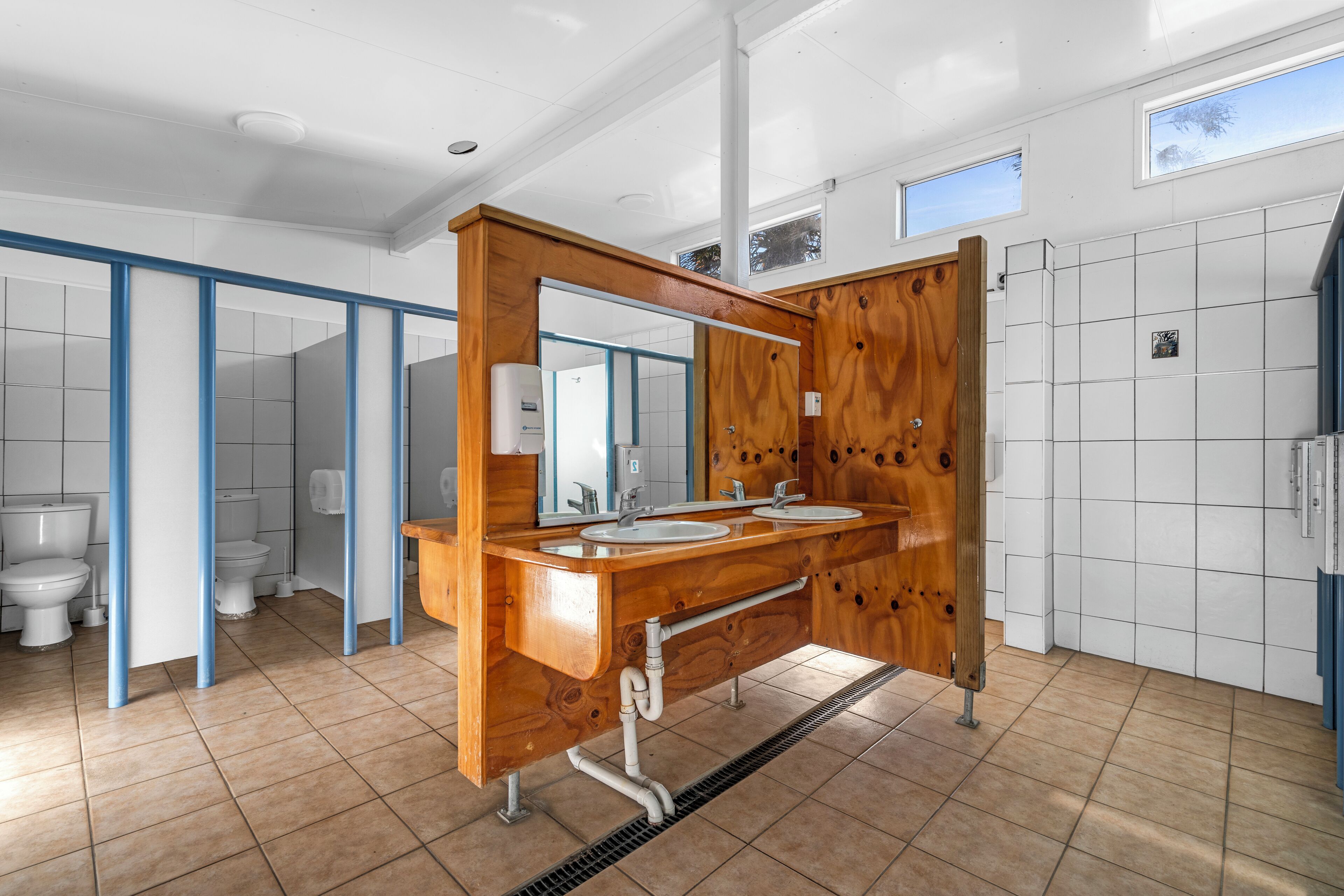 A modern bathroom with a wooden vanity, two sinks, and a large mirror.