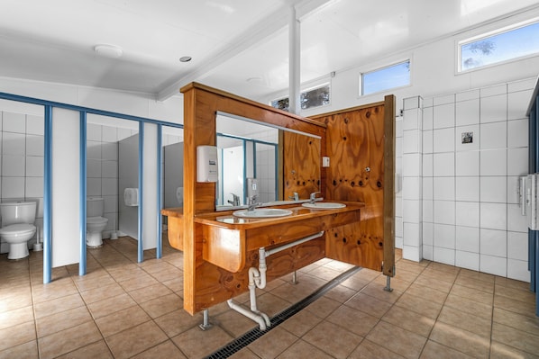 Une salle de bain moderne avec un meuble-lavabo en bois, deux vasques et un grand miroir.