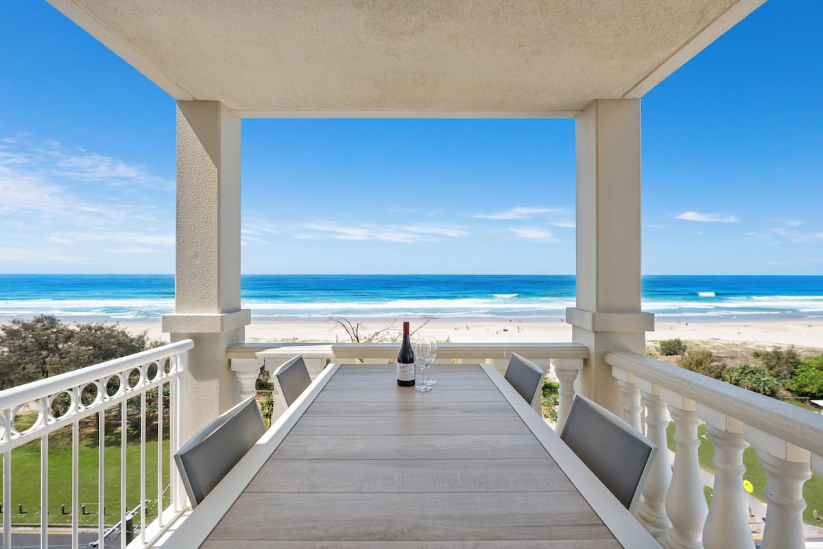 Uma varanda com vista para a praia e o oceano.