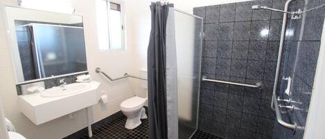 Ein modernes Badezimmer mit Waschbecken, Toilette und einer Duschkabine aus Glas.