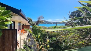 A modern house with a deck overlooking a scenic lake and mountains. - Opononi Lighthouse Motel (Opononi)