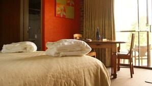 A hotel room with a bed, a desk, a chair, and a window with curtains. - Yallambee (Bundanoon)