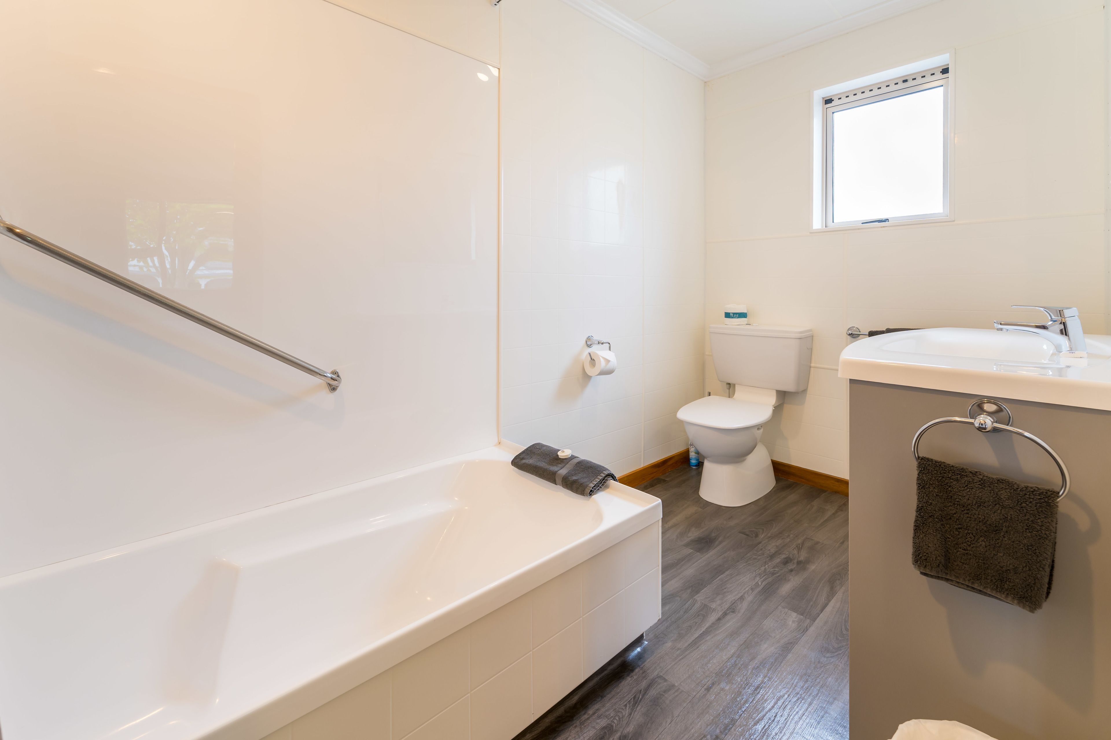 A modern bathroom with a bathtub, toilet, and sink.