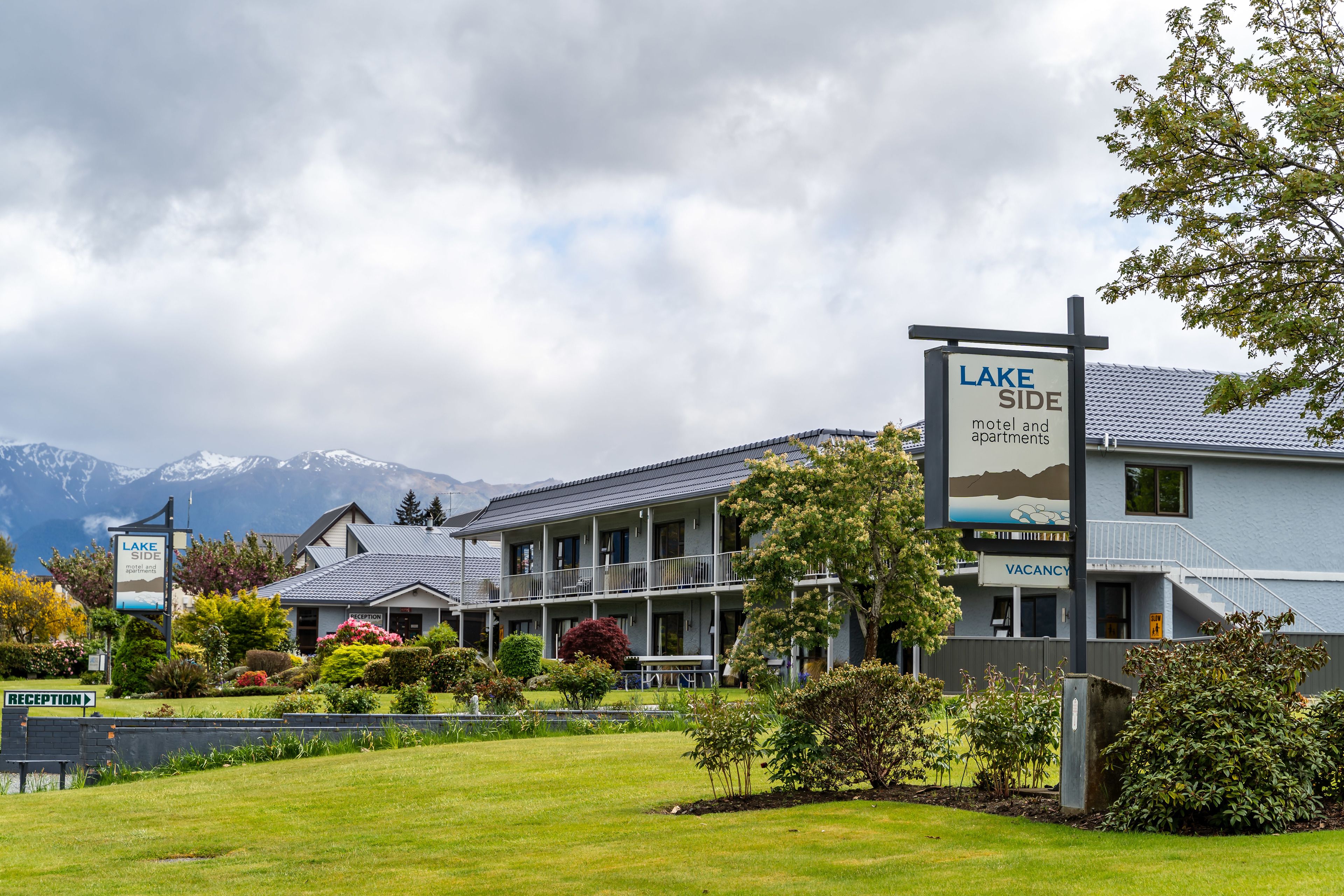 A motel and apartments with a sign indicating 'Lake Side' and 'Vacancy'.