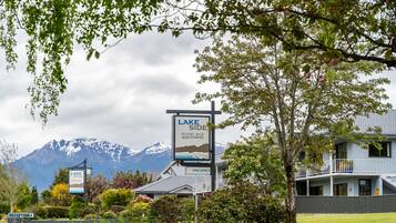 Een hotel genaamd 'Lake Side' met een bord waarop 'motel en appartementen' en een 'VACANCY' bord staat.
