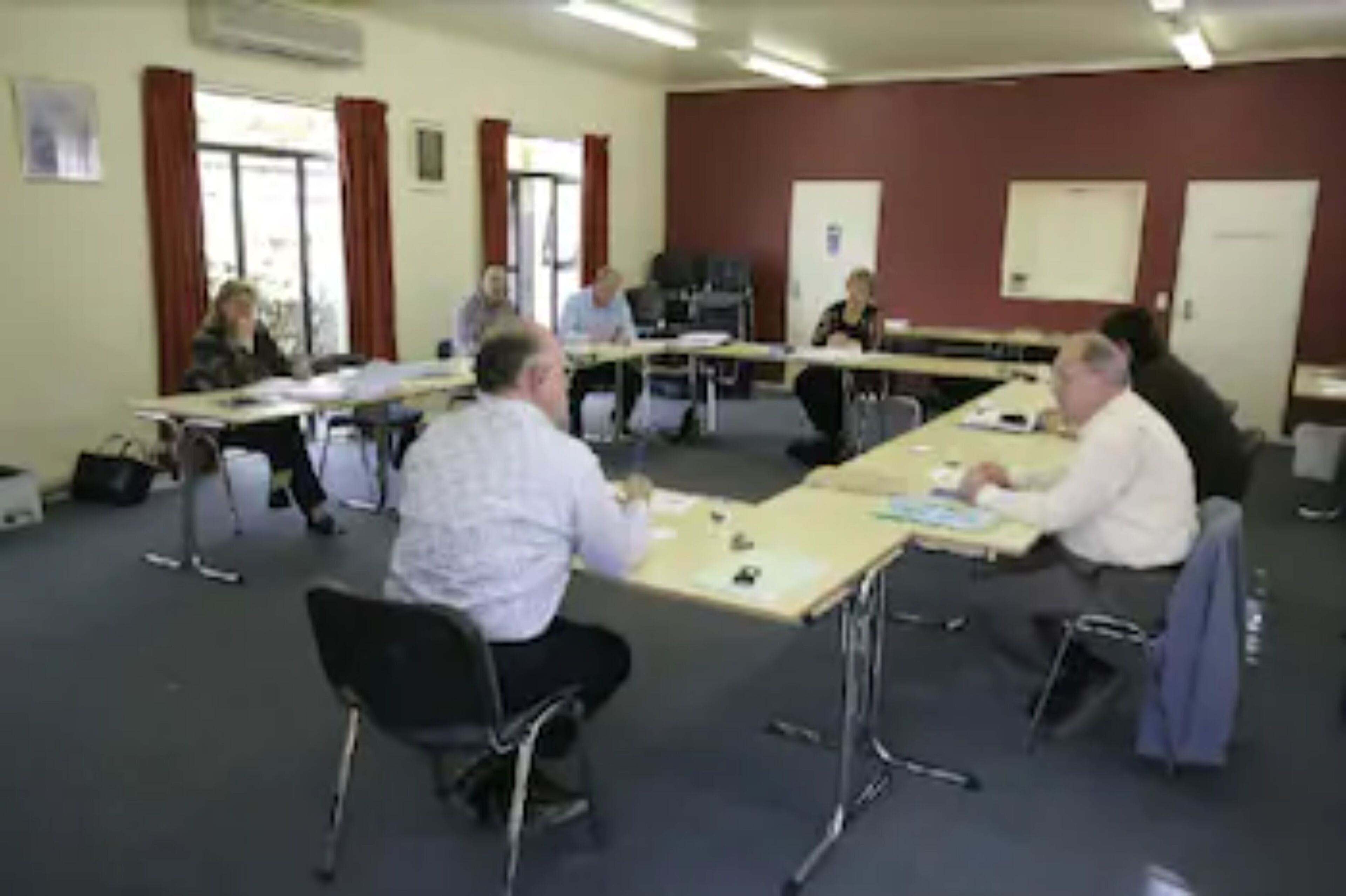 Una sala de conferències amb taules i cadires disposades per una reunió.