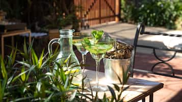 A patio with a table set for drinks, a pitcher, and a bucket.