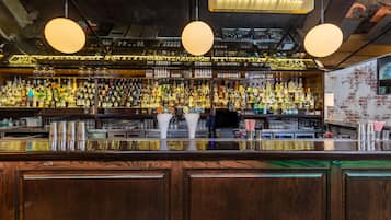 Un bar avec un comptoir en bois et une variété de bouteilles d’alcool.