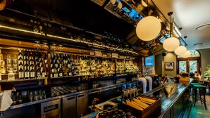 A bar with a variety of liquor bottles, a digital clock, and a sign that reads "Golden State." - Hotel Coronation (Sydney)