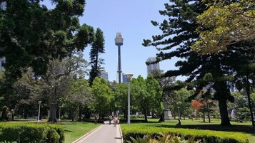 A park with a tall tower, trees, and a pathway.