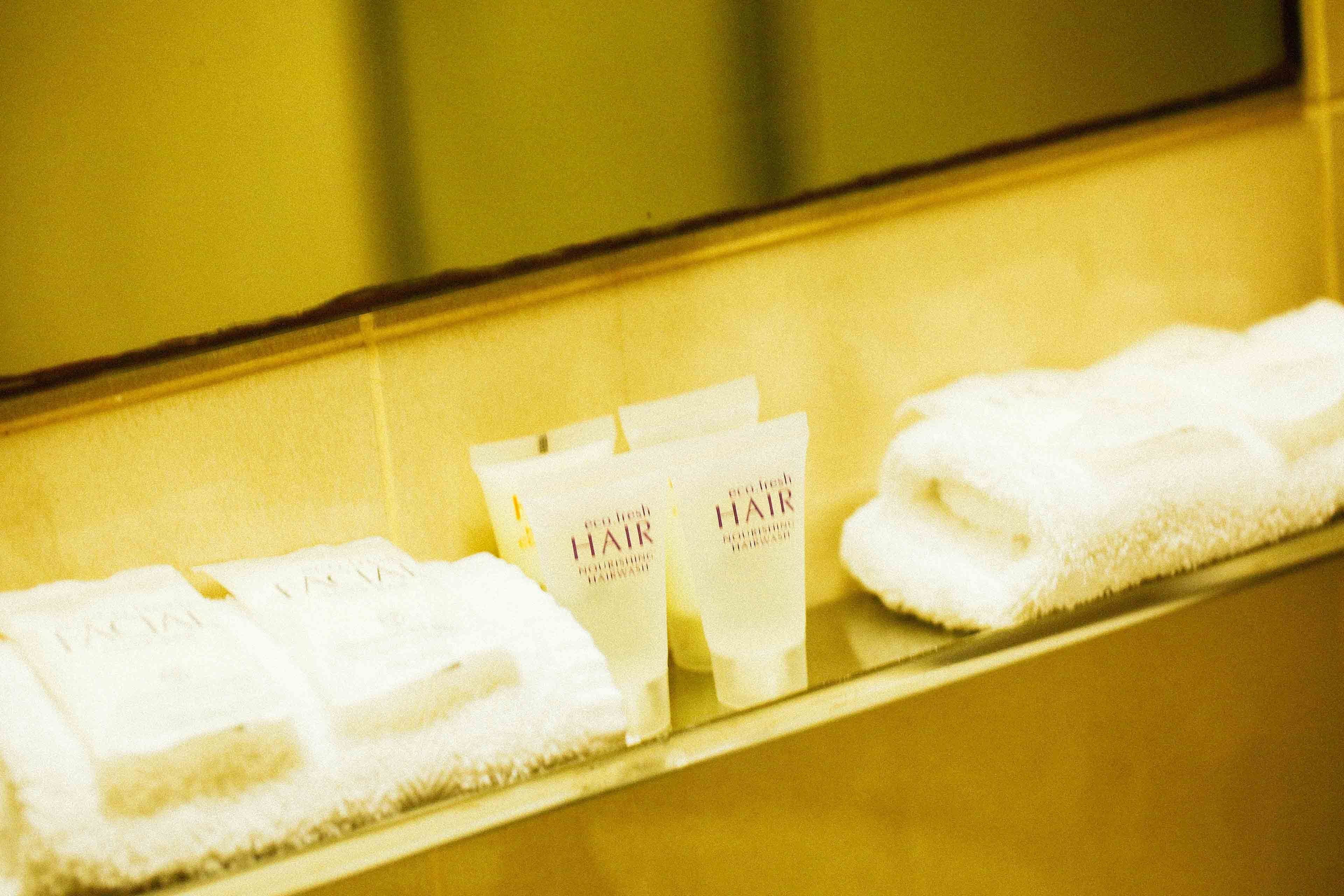 Una encimera de baño con toallas y productos para el cabello.